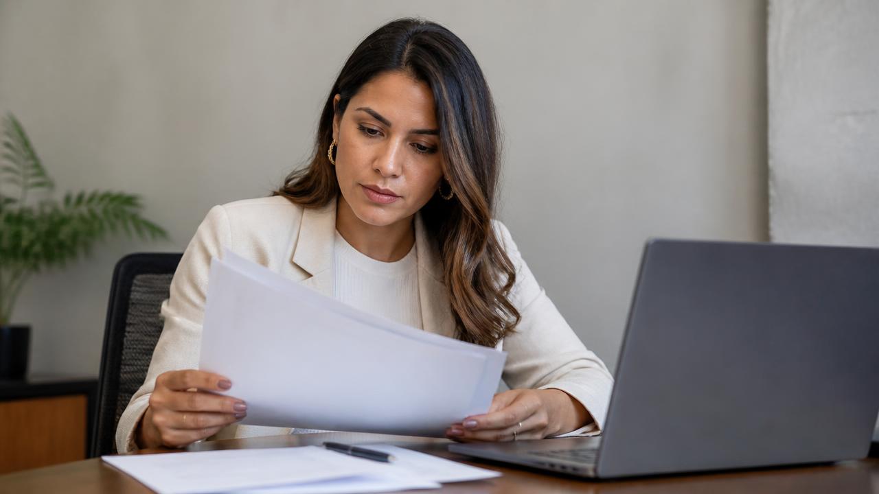 Consultora analisando documentos e dados no computador